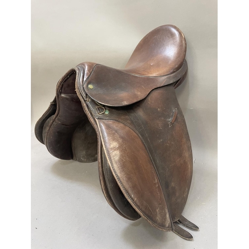 485 - A leather saddle stamped Britannia together with a bridle, reins bit and stirrups