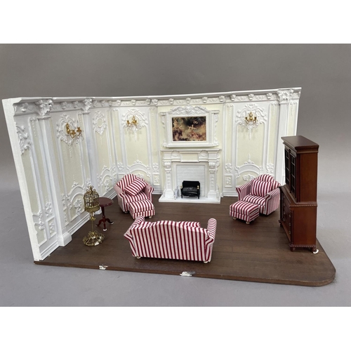 448 - A diorama of a Georgian style living room, having two heavily stuccoed walls, wall sconces, a painti... 