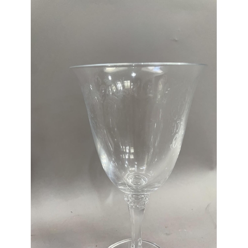 121 - A suite of twelve wine glasses having flared rims with etched bowls on knopped setms