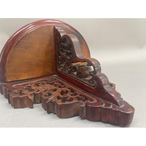 40 - A fruitwood wall shelf, the back and support heavily carved and pierced with foliate forms, having s... 