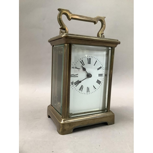 24 - A gilt brass carriage clock with enamel dial and black Roman numerals, visible escapement, 15cm high