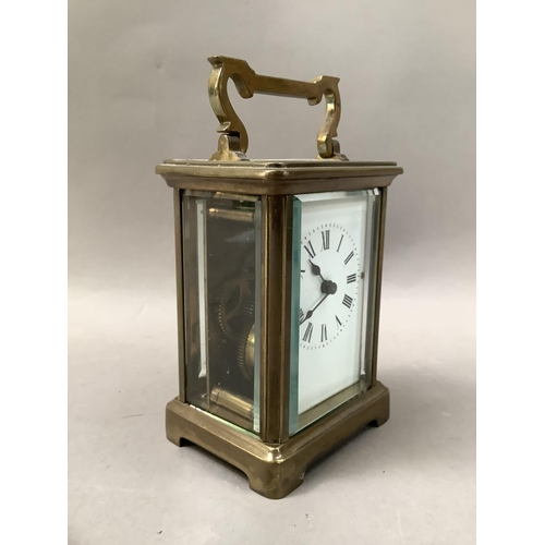 24 - A gilt brass carriage clock with enamel dial and black Roman numerals, visible escapement, 15cm high