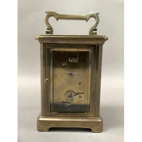 24 - A gilt brass carriage clock with enamel dial and black Roman numerals, visible escapement, 15cm high