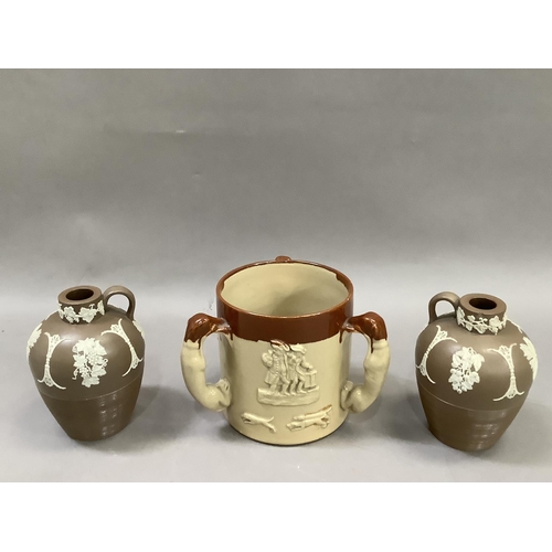 25 - A salt glaze loving cup with three handles formed as greyhounds together with two brown glazed jaspe... 