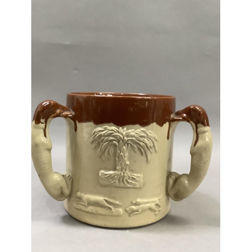 25 - A salt glaze loving cup with three handles formed as greyhounds together with two brown glazed jaspe... 