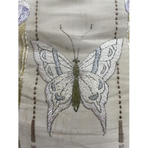 54 - A large silk cushion, the front embroidered with two bearded iris and a butterfly, having rope edgin... 