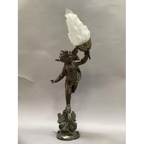 36 - After Emile Bruchon, a spelter table lamp formed as a winged cherub holding a flaming torch, stood a... 