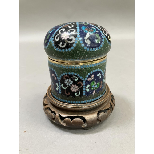 2 - A cloisonne jar and cover having insects and flowers on a green, blue and black ground, 11cm high in... 