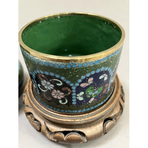 2 - A cloisonne jar and cover having insects and flowers on a green, blue and black ground, 11cm high in... 