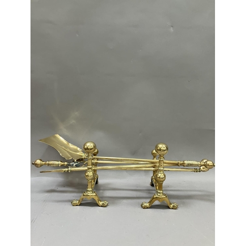 70 - A Victorian brass fireside companion set together with two firedogs