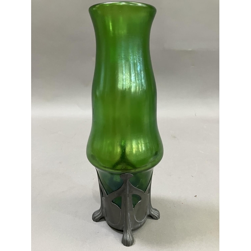 6 - A Loetz style vase of opaque lustre green glass within a pewter stand on four feet, 27cm high