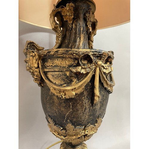 34 - A composite table lamp of campana urn form, having twin masks to the shoulders and swag decoration, ... 