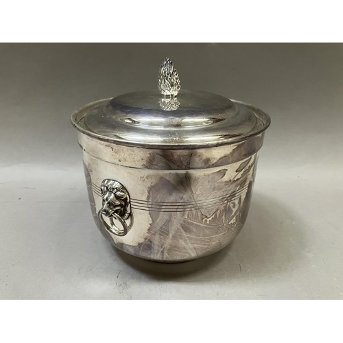 7 - A silver plated ice bucket having a flower bud finial, twin lion mask handles with ring pulls, and i... 