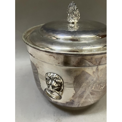 7 - A silver plated ice bucket having a flower bud finial, twin lion mask handles with ring pulls, and i... 