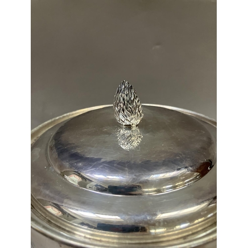 7 - A silver plated ice bucket having a flower bud finial, twin lion mask handles with ring pulls, and i... 