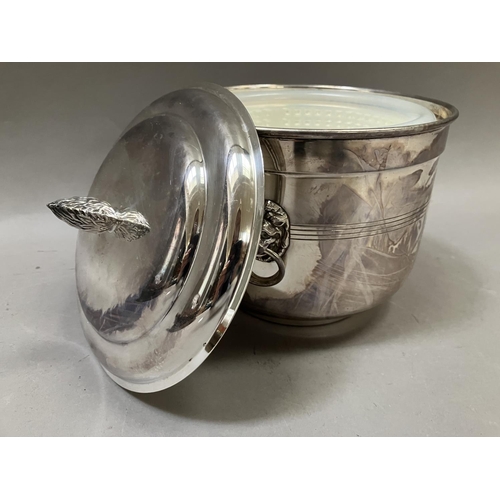 7 - A silver plated ice bucket having a flower bud finial, twin lion mask handles with ring pulls, and i... 