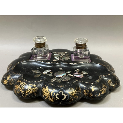 8 - A Victorian black lacquered inkstand, painted with gilt and inlaid with mother of pearl having two i... 