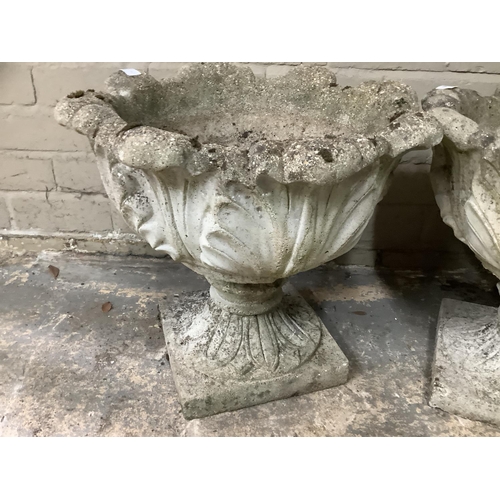 109 - A pair of cast garden planters formed of acanthus leaves with swept socles on square bases