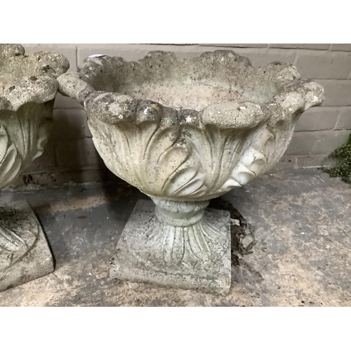 109 - A pair of cast garden planters formed of acanthus leaves with swept socles on square bases