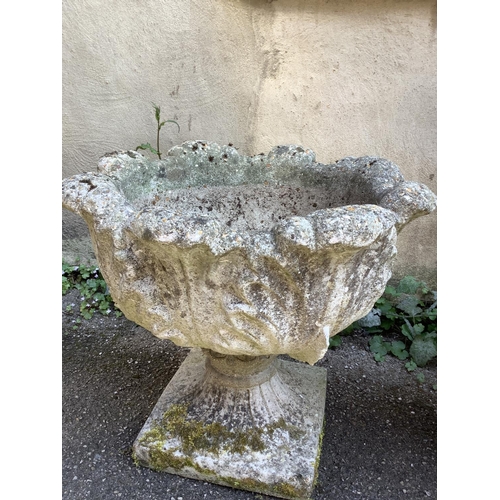 111 - A cast, garden planter formed of acanthus leaves with a swept socles with  square base together with... 