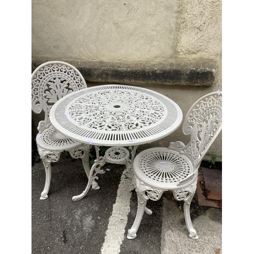 113 - A cast iron  white painted garden table with two high backed chairs