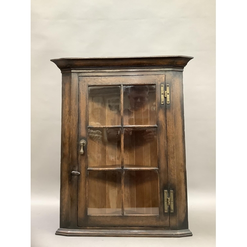 78 - An oak corner cupboard with a glazed door and 'H' hinges