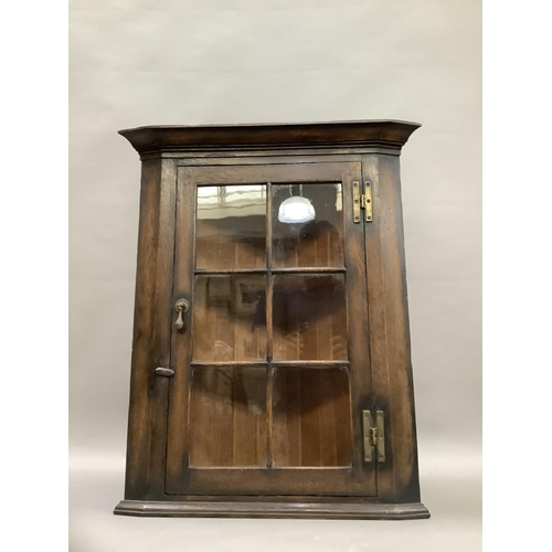 78 - An oak corner cupboard with a glazed door and 'H' hinges