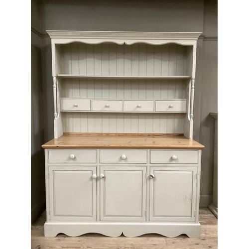 82 - A pine, painted, kitchen dresser in grey, having a plate rack above four drawers on a cupboard base ... 