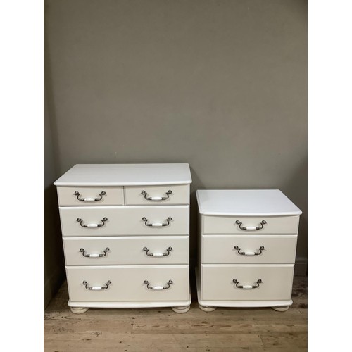 92 - A white chest of two short over three drawers having brushed chrome handles on bun feet together wit... 