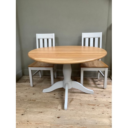 90 - A oak and grey painted circular dining table with two farmhouse chairs