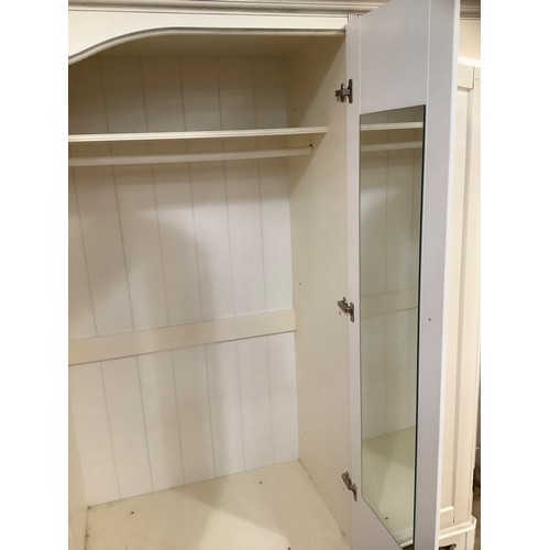 97 - A cream continental-style triple wardrobe having a straight top with moulded corners on bracket feet... 