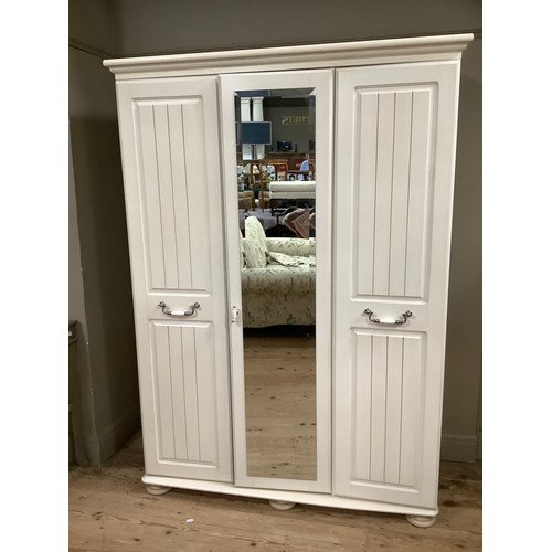 99 - A cream, mirrored triple wardrobe, the mirrored door surmounted by two panel doors with brushed chro... 