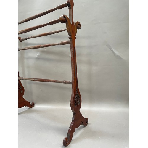 100 - An Edwardian, mahogany towel rail with two pierced ends