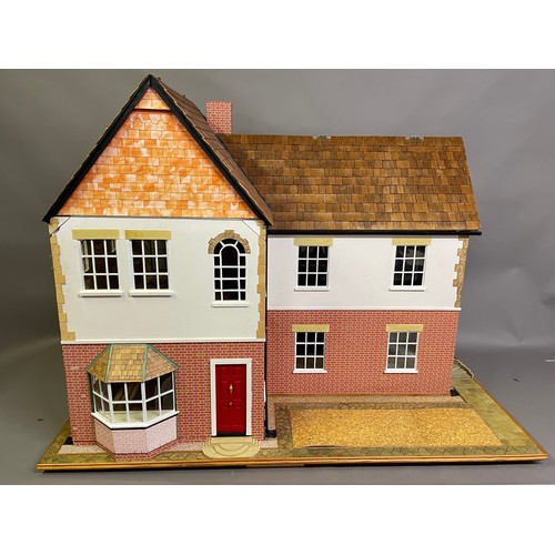 499 - A large dolls house on a wheeled plinth with opening front and rear, opening roof panels, a passenge... 