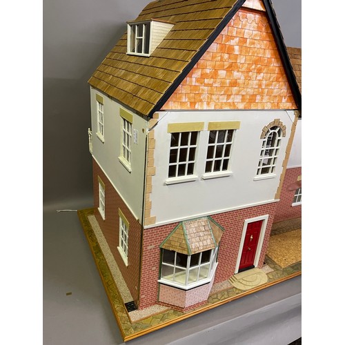 499 - A large dolls house on a wheeled plinth with opening front and rear, opening roof panels, a passenge... 