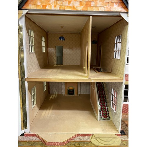 499 - A large dolls house on a wheeled plinth with opening front and rear, opening roof panels, a passenge... 