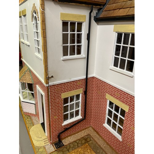 499 - A large dolls house on a wheeled plinth with opening front and rear, opening roof panels, a passenge... 