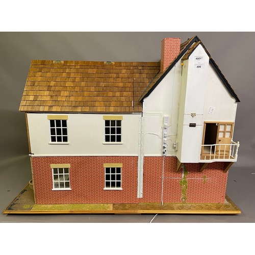 499 - A large dolls house on a wheeled plinth with opening front and rear, opening roof panels, a passenge... 