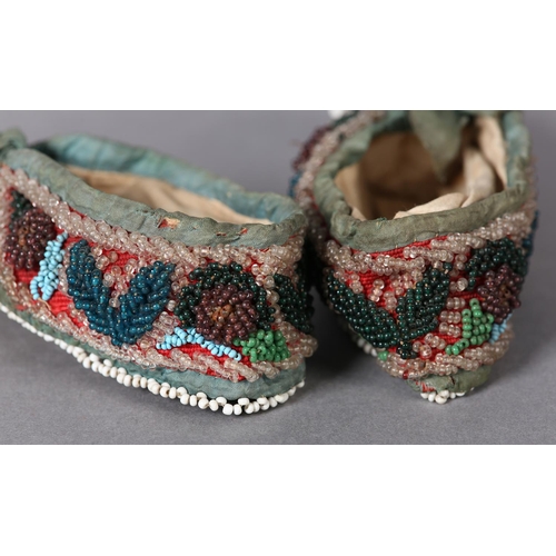 69 - A PAIR OF MID 19TH CENTURY CHILD'S BEADED SLIPPERS, worked in turquoise, teal, aubergine, green and ... 