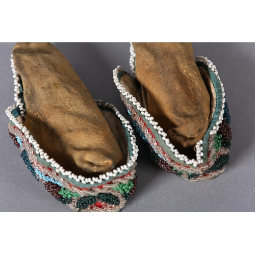 69 - A PAIR OF MID 19TH CENTURY CHILD'S BEADED SLIPPERS, worked in turquoise, teal, aubergine, green and ... 