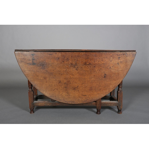 378 - AN 18TH CENTURY OAK OVAL GATELEG DINING TABLE having twin drop leaves, on turned and square framing,... 