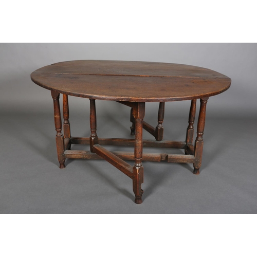 378 - AN 18TH CENTURY OAK OVAL GATELEG DINING TABLE having twin drop leaves, on turned and square framing,... 