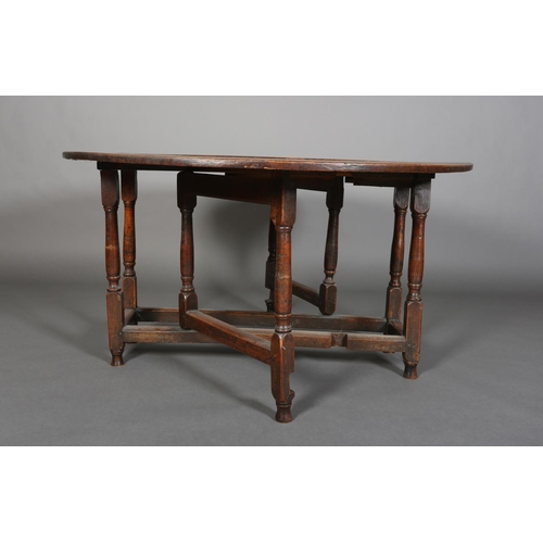 378 - AN 18TH CENTURY OAK OVAL GATELEG DINING TABLE having twin drop leaves, on turned and square framing,... 