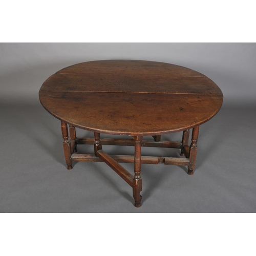 378 - AN 18TH CENTURY OAK OVAL GATELEG DINING TABLE having twin drop leaves, on turned and square framing,... 