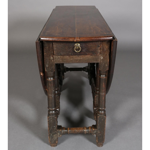 374 - AN 18TH CENTURY OAK OVAL GATELEG DINING TABLE having twin drop leavers and a drawer to either end wi... 