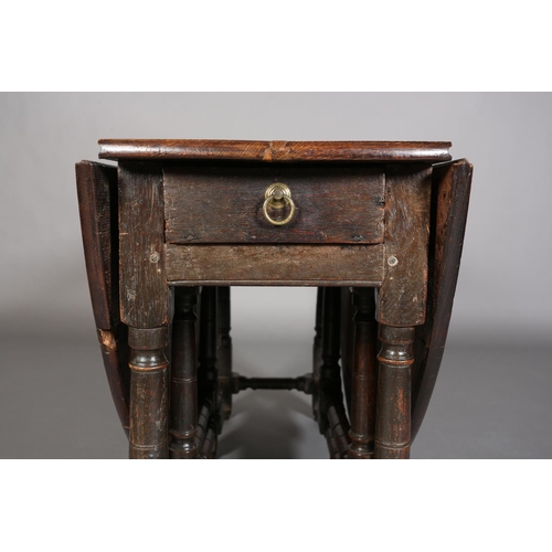 374 - AN 18TH CENTURY OAK OVAL GATELEG DINING TABLE having twin drop leavers and a drawer to either end wi... 