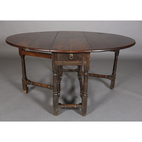 374 - AN 18TH CENTURY OAK OVAL GATELEG DINING TABLE having twin drop leavers and a drawer to either end wi... 