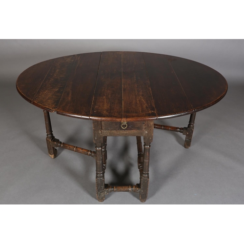 374 - AN 18TH CENTURY OAK OVAL GATELEG DINING TABLE having twin drop leavers and a drawer to either end wi... 