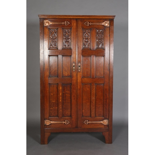 316 - AN ARTS & CRAFTS OAK HALL ROBE, having a moulded cornice above two foliate carved panels and four fu... 