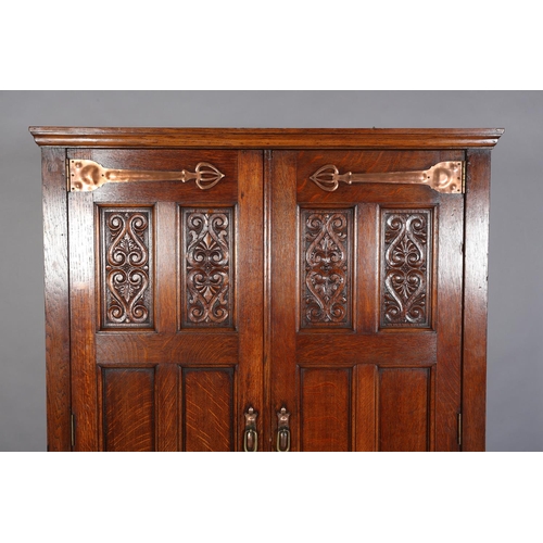 316 - AN ARTS & CRAFTS OAK HALL ROBE, having a moulded cornice above two foliate carved panels and four fu... 